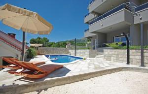 une maison avec une piscine, 2 chaises et un parasol dans l'établissement Villa EM, à Makarska