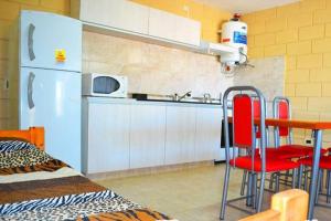 a kitchen with a refrigerator and a table and chairs at Malaquias in Villa Carlos Paz