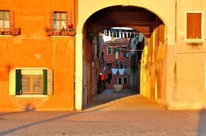 an alley with an archway in an orange building at 1410 Castello in Venice