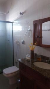 a bathroom with a toilet and a sink and a shower at Sobrado em Arraial do Cabo in Arraial do Cabo