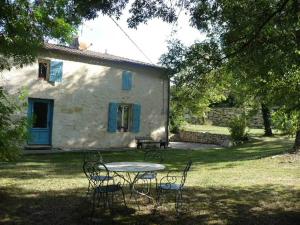 a table and chairs in front of a house at Domaine de Puycarpin in Belvès-de-Castillon