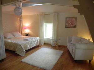 1 dormitorio con 1 cama, 1 silla y 1 ventana en Domaine de Puycarpin, en Belvès-de-Castillon