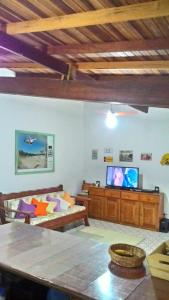 uma sala de estar com um sofá e uma televisão de ecrã plano em Juquehy Brothers House em Juquei