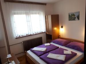 a bedroom with a purple bed and a window at Guest House Borić in Grabovac