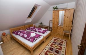 Un dormitorio con 2 camas y una silla. en Paulay Borház és Vendégház, en Tokaj
