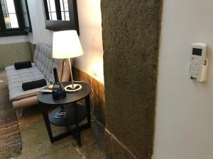 リスボンにあるGarcia Loft - Exquisite Spotのリビングルーム(ランプとソファ付きのテーブル付)