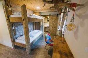 a room with two bunk beds and a desk at Hostel Lukna in Mojstrana