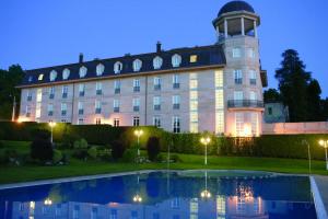 a building with a clock tower next to a pool at Balneario de Mondariz in Mondariz-Balneario