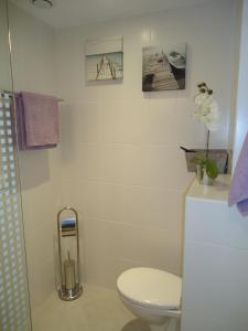 La salle de bains est pourvue de toilettes et de photos murales. dans l'établissement appartement, à Calvi