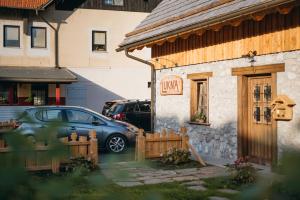 
a car parked in front of a house at Hostel Lukna in Mojstrana
