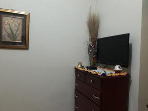 a dresser with a television on top of it at Jacaranda Homes in Spanish Town