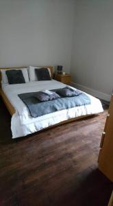 a bed in a bedroom with a wooden floor at The Haven Cottage in Slamannan