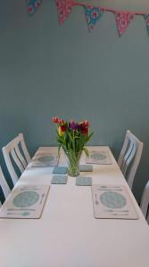 una mesa con un jarrón de flores. en The Haven Cottage en Slamannan