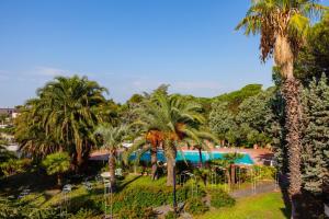 a view of a resort with palm trees and a pool at Villa Viuli in Torre del Greco