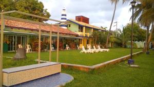 a building with a yard with chairs and a lighthouse at Hotel Marina San Blas in San Blas