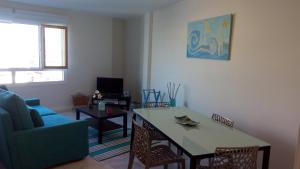マラガにあるQuiet Downtown Apartamentのリビングルーム(テーブル、青いソファ付)