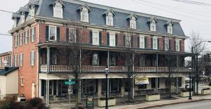 a large red brick building on a city street at Waynebrook Inn in Honey Brook