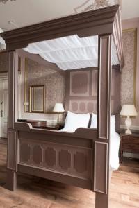Hotel Fidder - Patrick's Whisky Bar في زفوله: سرير كبير مظلة في غرفة النوم مع مصباحين