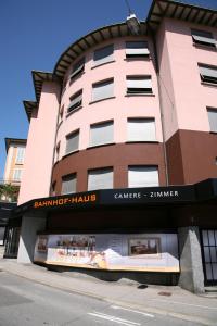 a tall building with a sign in front of it at Hotel Bahnhof Haus in Chiasso