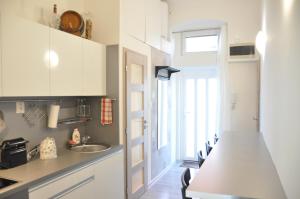 uma cozinha com armários brancos e um lavatório em Modern & Historic Apartment em Bratislava