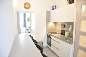 uma cozinha com armários brancos e uma bancada em Modern & Historic Apartment em Bratislava