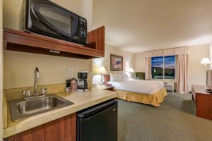 ein Hotelzimmer mit einem Bett und einer Küche mit einem Waschbecken in der Unterkunft Grand River Hotel in Parachute