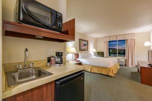 a hotel room with a bed and a kitchen with a sink at Grand River Hotel in Parachute