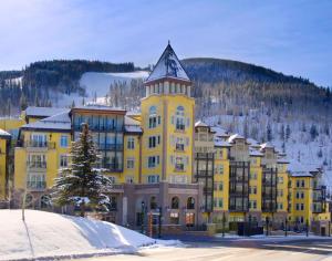 a yellow building with a tower on top of it at The Vail Collection at the Ritz Carlton Residences Vail in Vail