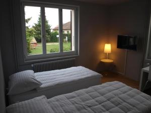 1 dormitorio con 2 camas y ventana en Auberge de Founex, en Founex