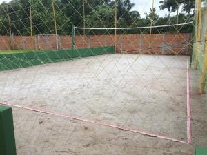 una pista de tenis con una red encima en Pousada Recanto Das Garças en Rio Preto Da Eva