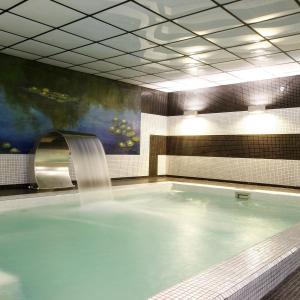 a large swimming pool with a water fall at Apartamentos Spa Cueto in Cangas de Onís