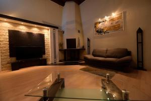 un soggiorno con divano e tavolo in vetro di H & V Residence - Split Level Apartment a Arad