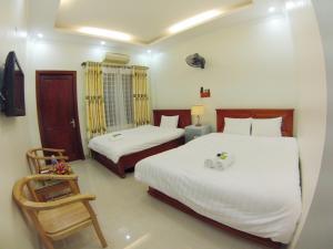 a hotel room with two beds and a chair at ninh binh friendly hotel in Ninh Binh