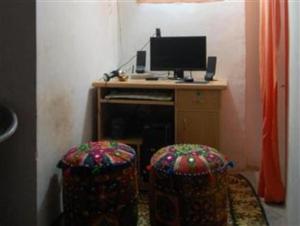 a room with two stools and a television on a desk at Tanisha Heritage Haweli in Bikaner
