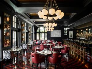 聖巴巴拉的住宿－凱麗佛潤酒店，餐厅设有红色的桌椅和吊灯