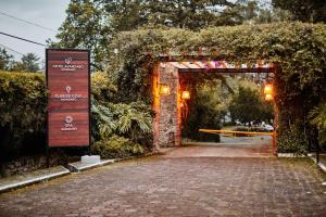an entrance to a garden with an arch and a brick road at Hotel Avandaro Golf & Spa Resort in Valle de Bravo