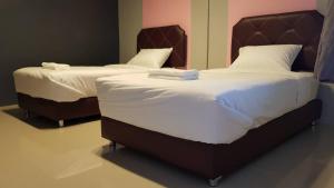 Habitación con 2 camas individuales y sábanas blancas. en Baan Sang Chan 3 en Ban Krang