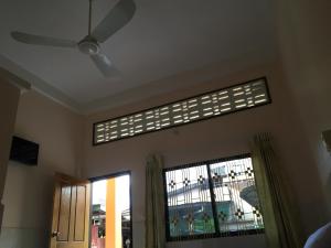 a room with a ceiling fan and a window at Ta Eng Guesthouse in Kampot