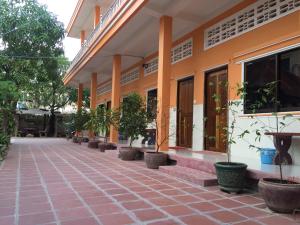 einen Innenhof eines Gebäudes mit Topfpflanzen in der Unterkunft Ta Eng Guesthouse in Kampot