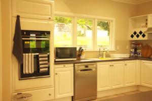 y cocina con nevera y microondas. en Lake Domain Boarding Holiday House en Hamilton