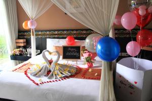 a bedroom with balloons and a bed with a cake at Villa Jerami in Seminyak
