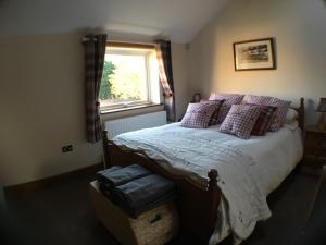 1 dormitorio con cama con almohadas y ventana en The Annex, en Seaton Burn