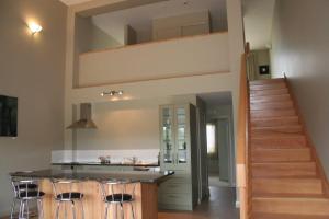 a kitchen with a counter and a staircase in a house at Leigh Apartments in Leigh