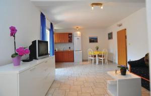 a living room with a tv and a kitchen at Apartman JADRANKO Murter in a quiet environment near the center and the beach in Murter