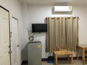 a room with a refrigerator and a tv and a window at Y&N House in Prachuap Khiri Khan