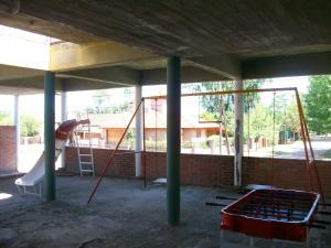 uma área recreativa com escorrega e um parque infantil em Hosteria Columbia em Mina Clavero