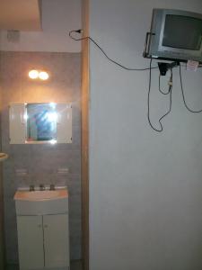 a bathroom with a sink and a tv on the wall at Hosteria Columbia in Mina Clavero +23 photos