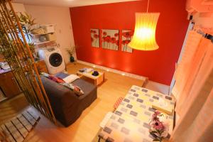 a living room with a couch and a red wall at Lucy's House 横浜中華街 House2 in Yokohama