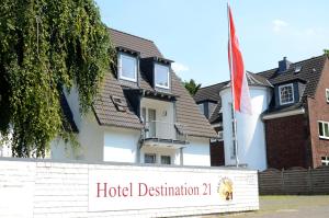 a white house with a flag on the front of it at Hotel Destination 21 in Düsseldorf