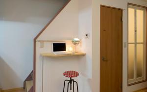 a staircase with a laptop on a shelf and a stool at Lucy's House横浜中華街 House3 in Yokohama